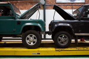 Two Land Rover Defenders bumper to bumper with their bonnets open at CSG Automotive Alderley Edge